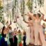Bridesmaids and guests are singing and dancing in the marquee.