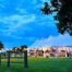 A picture of outside the marquee in the evening with a fence and trees.