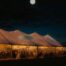 A view of the marquee outside at night with the moon in the sky.
